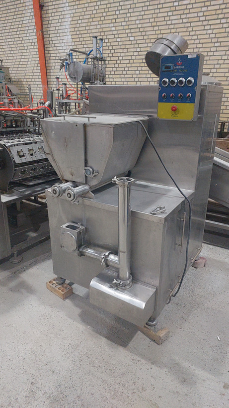Modern ice cream production line with fruit feeder, fresh fruits and nuts being mixed into vanilla ice cream, stainless steel machinery, high-end dairy factory, photorealistic